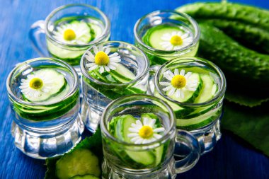 Salatalık suyu mavi zemin üzerine altı küçük mason cam kavanoza. Rustik. Detoks