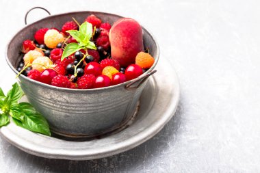 Meyve ve çilek gri metal kabın içinde karıştırın. Yakın çekim.