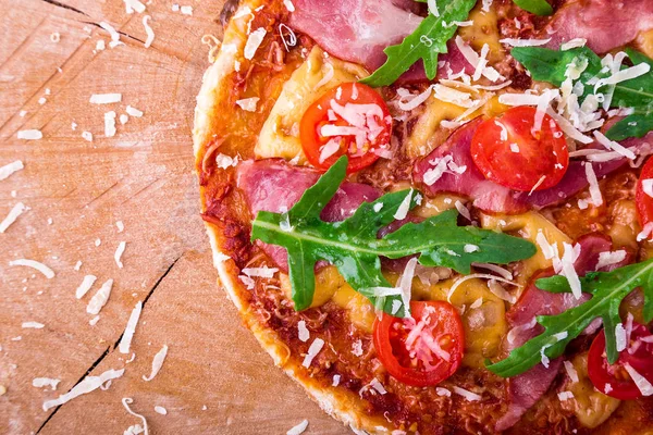 Ev yapımı pizza salam, domates, roka ahşap Pano mavi zemin üzerine. Üstten Görünüm.