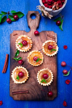 Karamel küçük ahşap tahta ve rustik arka plan mavi tarts elma. Cennet elması ile Fransız tatin. Üstten Görünüm