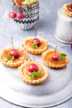 Elma gri arka plan üzerine karamel küçük tarts. Cennet elması ile Fransız tatin.