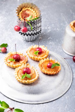 Elma gri arka plan üzerine karamel küçük tarts. Cennet elması ile Fransız tatin.