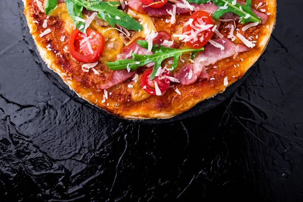 Ev yapımı pizza salam, domates, roka siyah arduvaz gemide. Üstten Görünüm. Kopya alanı.