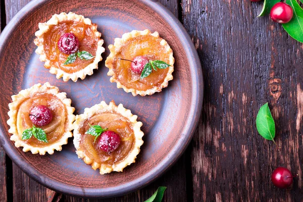 Tarte mici de caramel de mere pe fundal rustic maro. Tatuaj francez cu mere paradis. Privire de sus . — Fotografie, imagine de stoc