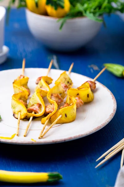 Kabak ve tavuk kebap beyaz plaka ve mavi arka plan üzerinde tahta sopa üzerinde. Yakın çekim