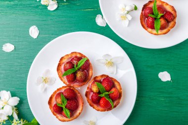 Çilek tartı yeşil zemin üzerine beyaz Tabaklarda. Üstten Görünüm.