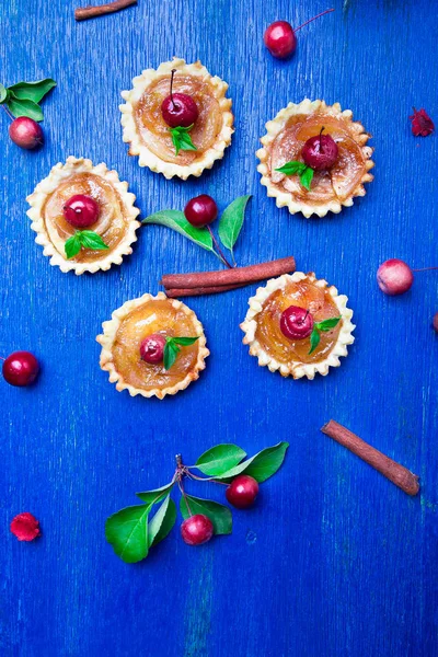Apple caramel little tarts on blue rustic background. French tatin with paradise apple. Top view — Stock Photo, Image