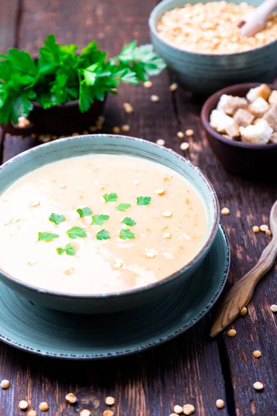 Soupe de pois dans un bol vert sur fond de bois brun. Pois jaune sec. Alimentation végétalienne . — Photo