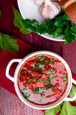 Ukraynalı geleneksel borsch. Kırmızı ahşap arka plan üzerinde beyaz kase Rus vejetaryen kırmızı çorba. Üstten Görünüm. Pancar çorbası, pancar ile borshch.