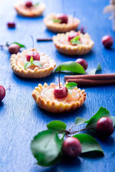 Tarte mici caramel de mere pe fundal rustic albastru. Tatuaj francez cu mere paradis — Fotografie, imagine de stoc