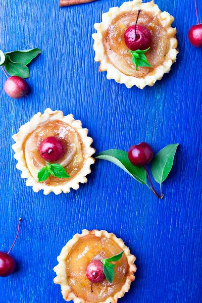 Karamel küçük mavi rustik arka plan üzerinde tarts elma. Cennet elması ile Fransız tatin. Üstten Görünüm. Çerçeve. Kopya alanı.