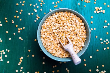 Yeşil zemin üzerine yeşil kase kuru sarı bezelye. Üstten Görünüm.