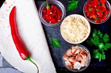 Siyah arduvaz taş plaka üzerinde salsa ile mexican quesadilla için malzemeler. Üstten Görünüm.