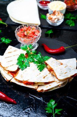 Mexican quesadilla siyah arduvaz taş plaka üzerinde salsa sos ile. Biber biber.
