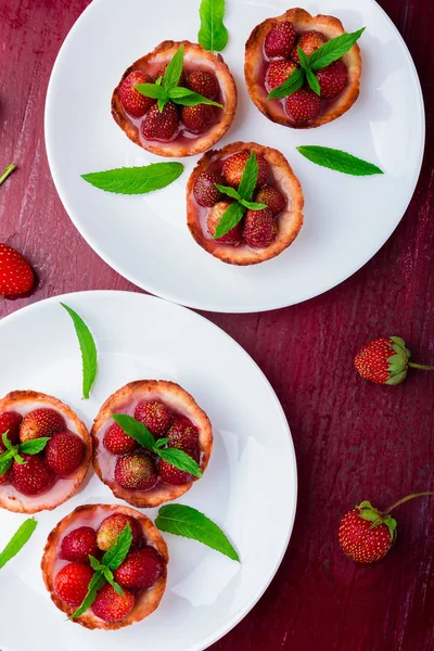 Tartaleta de fresa sobre platos blancos sobre fondo rojo. Vista superior . — Foto de Stock