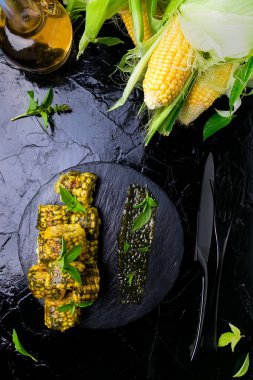 Izgarada Mısır siyah arduvaz plaka üzerinde pesto sos ile. Üstten Görünüm. Vegan gıda.