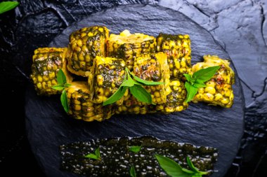 Izgarada Mısır siyah arduvaz plaka üzerinde pesto sos ile. Üstten Görünüm. Vegan gıda.