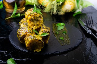 Izgarada Mısır siyah arduvaz plaka üzerinde pesto sos ile. Yakın çekim. Vegan gıda.