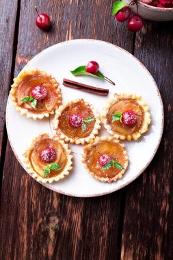 Karamel küçük tarts beyaz plaka ve kahverengi rustik zemin üzerinde Apple. Cennet elması ile Fransız tatin. Üstten Görünüm.