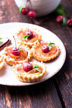 Karamel küçük tarts beyaz plaka ve kahverengi rustik zemin üzerinde Apple. Cennet elması ile Fransız tatin.