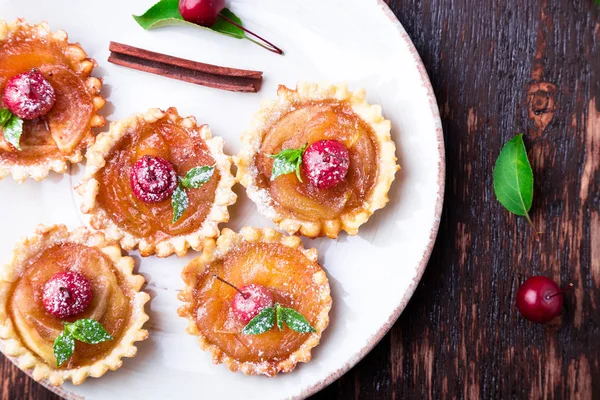 Karamel küçük tarts beyaz plaka ve kahverengi rustik zemin üzerinde Apple. Cennet elması ile Fransız tatin. Üstten Görünüm.