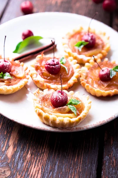 Tarte mici de caramel de mere pe placă albă și fundal rustic maro. Tatuaj francez cu mere paradis . — Fotografie, imagine de stoc