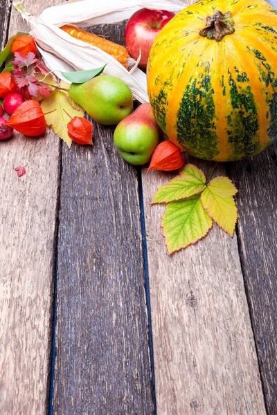 Thanksgiving background with autumn fruits and gourds on a rustic wooden table. Autumn harvest. Top view. Copy space. Thanksgiving frame