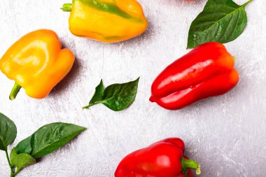 Kırmızı, turuncu ve sarı biber gri arka plan üzerinde. Sağlıklı organik sebze. Üstten Görünüm. Sanat sınır tasarlamak. Çerçeve