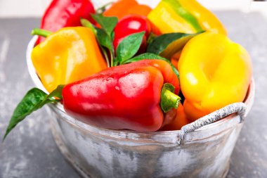 Kırmızı ve sarı biber gri sepet içinde. Sağlıklı organik sebze. Yakın çekim.