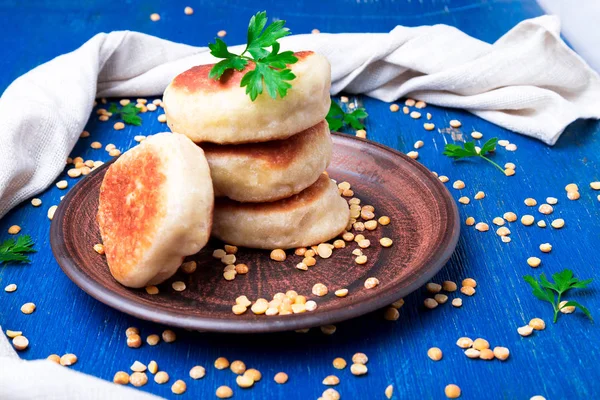 Kavrulmuş Bezelye patty mavi ahşap arka plan üzerinde kahverengi plaka havlu. Üstten Görünüm. 