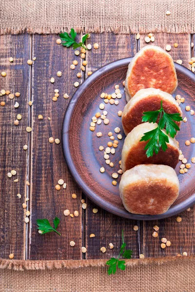 Ahşap arka plan üzerinde kahverengi plaka Kavrulmuş Bezelye patty. Üstten Görünüm. 