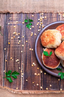 Ahşap arka plan üzerinde kahverengi plaka Kavrulmuş Bezelye patty. Üstten Görünüm. 