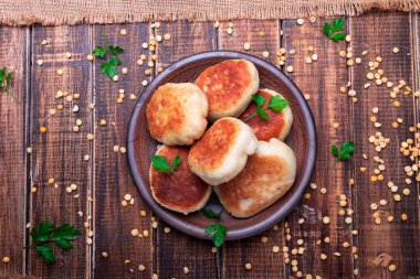 Ahşap arka plan üzerinde kahverengi plaka Kavrulmuş Bezelye patty. Üstten Görünüm. 