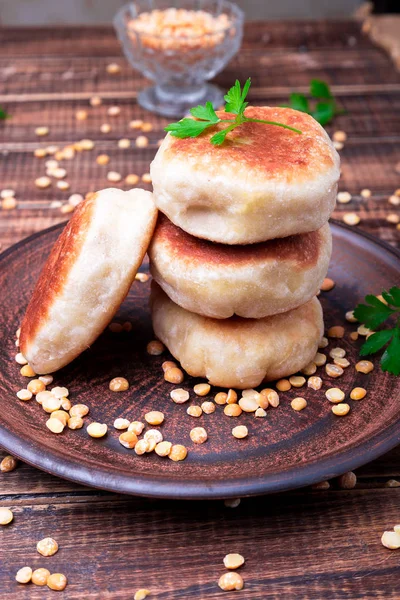 Ahşap arka plan üzerinde kahverengi plaka Kavrulmuş Bezelye patty. Yakın çekim.