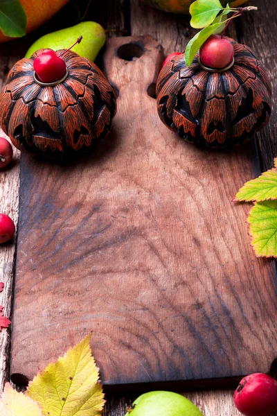 Jack-o lucernou kolem prázdných prkénko na dřevěné pozadí. Podzimní koncept. Halloween. Pohled shora. Kopírovat prostoru. Rámeček. — Stock fotografie