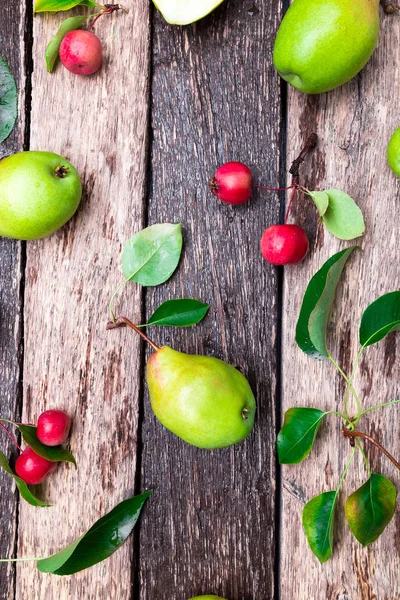 Peras y manzanas pequeñas sobre fondo rústico de madera. Vista superior. Una trampa. Cosecha de otoño . — Foto de Stock