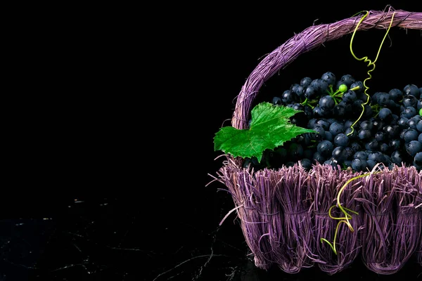 Uvas de vino tinto en canasta de voiolet sobre fondo bllack . — Foto de Stock