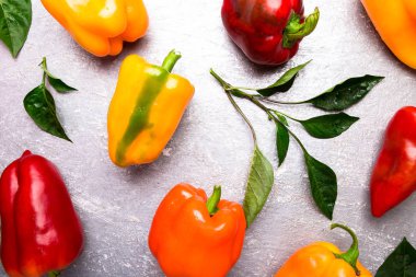 Kırmızı, turuncu ve sarı biber gri arka plan üzerinde. Sağlıklı organik sebze. Üstten Görünüm. Sanat sınır tasarlamak. Çerçeve
