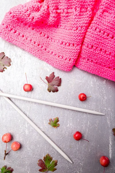 Foulard rose près des aiguilles à tricoter sur fond gris. Vue de dessus. Espace de copie . — Photo
