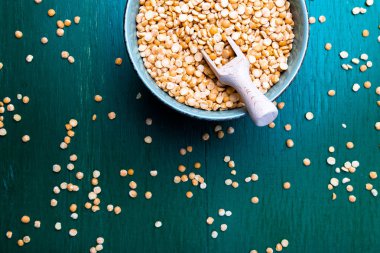 Yeşil zemin üzerine yeşil kase kuru sarı bezelye. Üstten Görünüm.