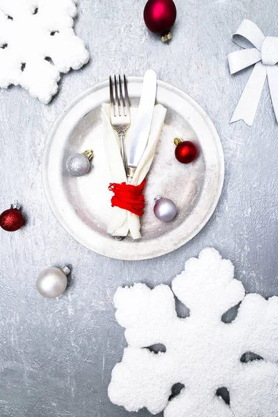 Noel tablo yer ayarını. Tatil arka plan. Gümüş tabak, bıçak ve çatal ile Noel süsleri. Üstten Görünüm.
