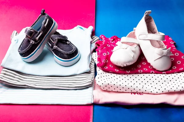 Bodysuit dobrado azul e rosa com sapatos de barco sobre ele em fundo minimalista rosa e azul. fralda para menino e menina recém-nascidos. Pilha de roupas infantis. Roupa de criança — Fotografia de Stock