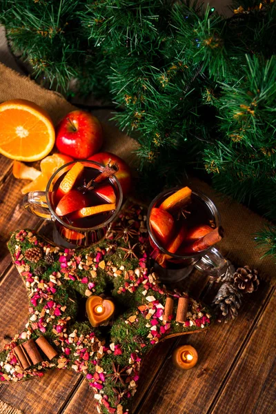 ホットワインの果物とスパイス木製テーブルの上の近くのクリスマスの星。バック グラウンドでのクリスマス装飾です。2 つのグラス。冬は周りのレシピ食材とドリンクを温暖化します。トップ ビュー. — ストック写真