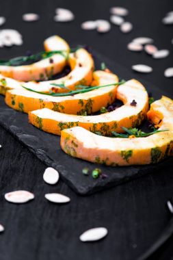 Siyah arka plan üzerine siyah arduvaz plaka üzerinde ızgara kabak