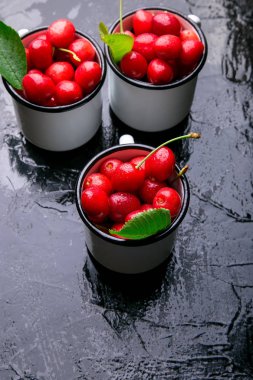 Kiraz emaye Kupası siyah arka plan üzerine. Sağlıklı, yaz meyve. Kiraz.