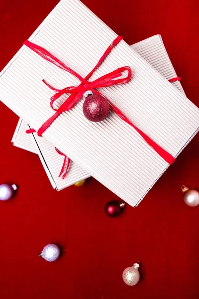 Caja de regalo de Navidad. Regalos de Navidad en cajas de artesanía y cinta roja sobre fondo rojo. Piso con espacio de copia. Estilo laico plano. Vista superior . — Foto de Stock