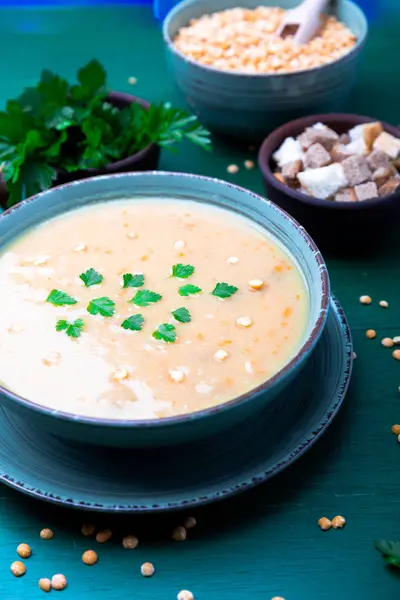 Soupe de pois dans un bol vert sur fond de bois vert. Vue de dessus. Pois jaune sec. Alimentation végétalienne . — Photo