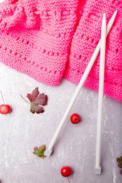 Foulard rose près des aiguilles à tricoter sur fond gris. Vue de dessus. Espace de copie. pose plate . — Photo