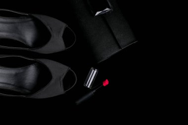 Moda Bayan aksesuar seti. Çok az. Ayakkabı, ruj ve çanta siyah arka plan üzerinde. Düz yatıyordu.