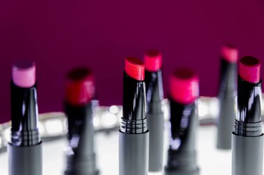 Mat ruj kırmızı ve doğal renkleri beyaz ve pembe arka plan üzerinde ayarlayın. Moda renkli ruj. Profesyonel makyaj ve güzellik. Yanıp sönen bokeh arka plan.